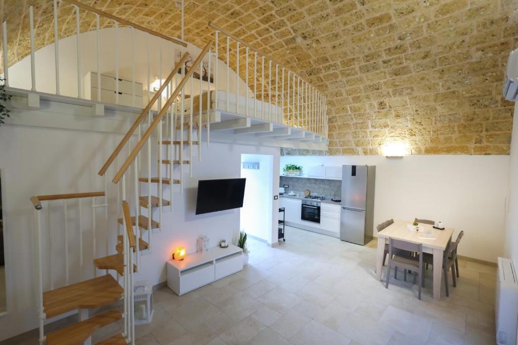 ein Wohnzimmer mit einer Treppe und ein Esszimmer in der Unterkunft Dimora Don Mimì in Morciano di Leuca