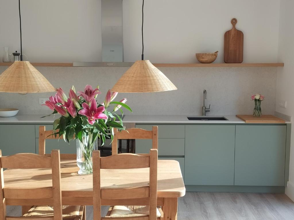 uma cozinha com uma mesa com um vaso de flores em Les Planes de Viladrau em Viladrau