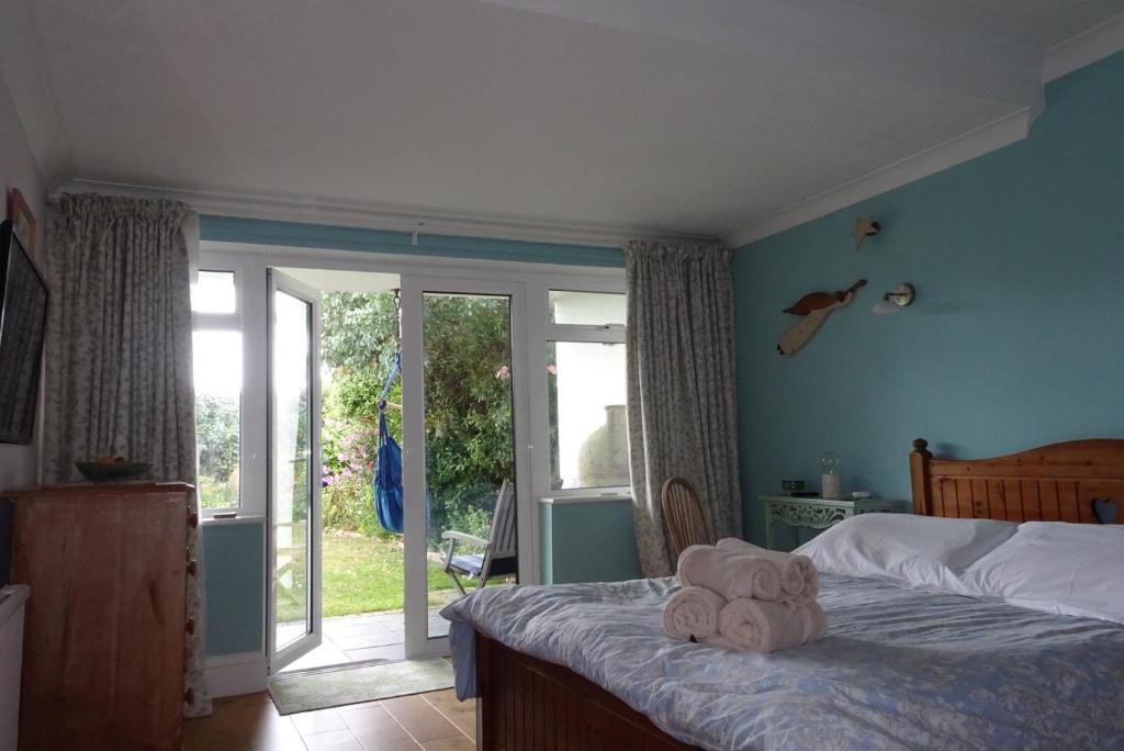 a bedroom with a bed with a stuffed animal on it at Cliff top Garden room in Milford on Sea