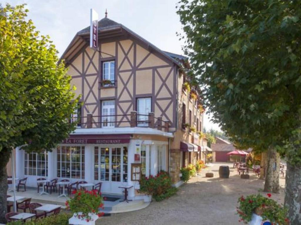 un grande edificio con una bandiera sopra di Le Chalet de la Foret Logis Hôtel 3 étoiles et restaurant a Vierzon