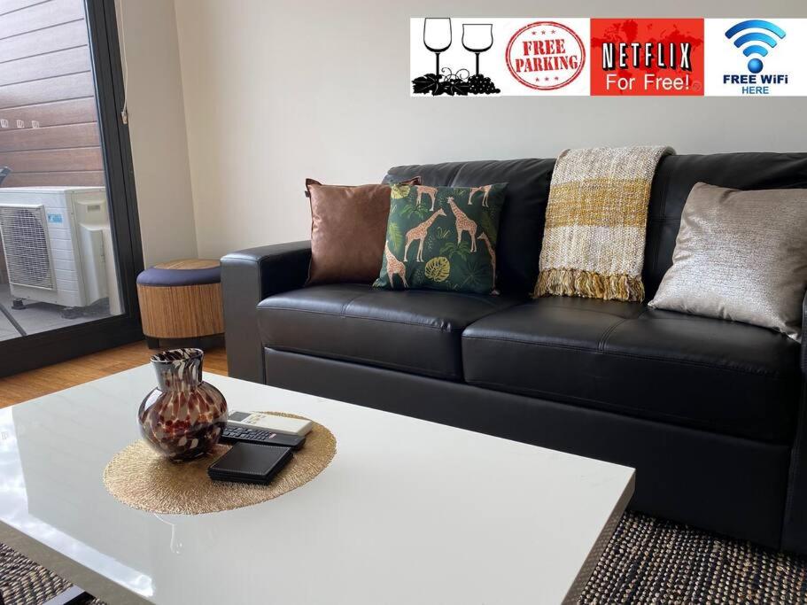 a living room with a black couch and a coffee table at Best Location Airport City River Marina Park&Wine in Perth