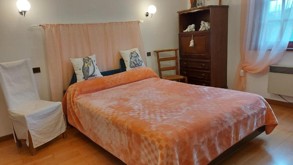 Caunes-Minervois的住宿－Villa Aimé，一间卧室配有一张大床和一把椅子