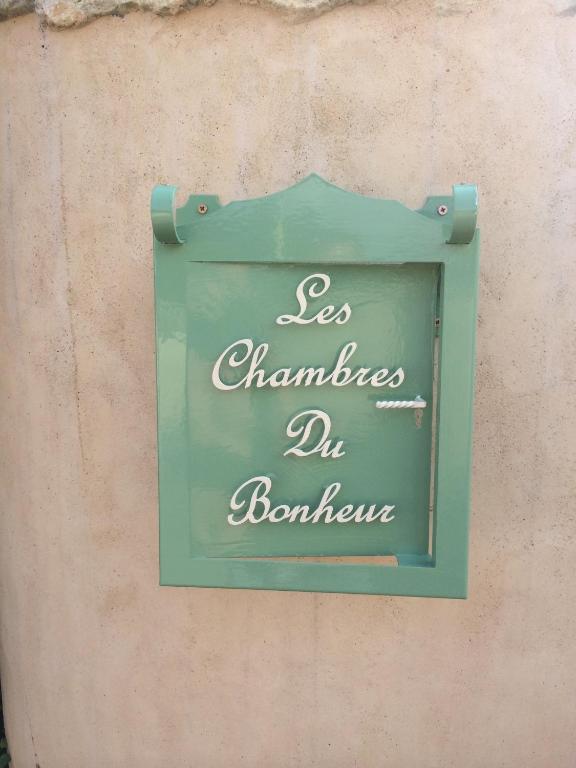 a green sign on the side of a wall at Les chambres du Bonheur in Fontaine-sous-Jouy