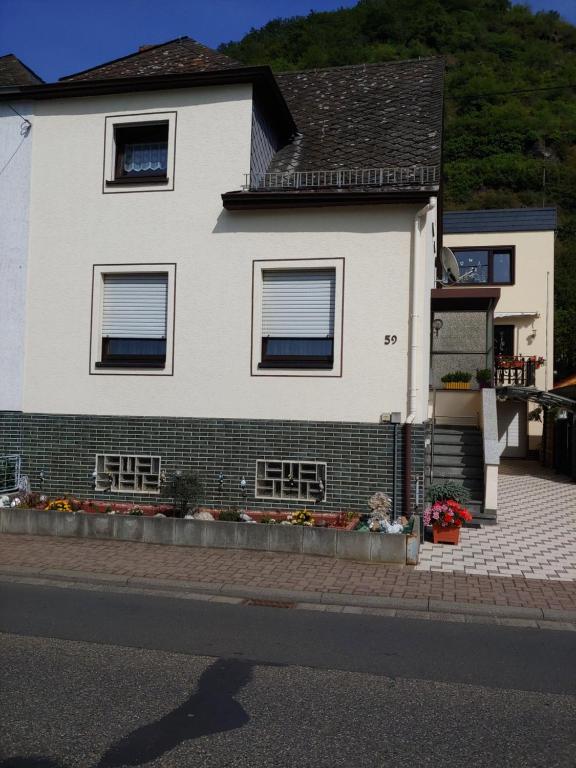 a white house on the side of a street at Gästehaus Rheinburgenblick in Kestert