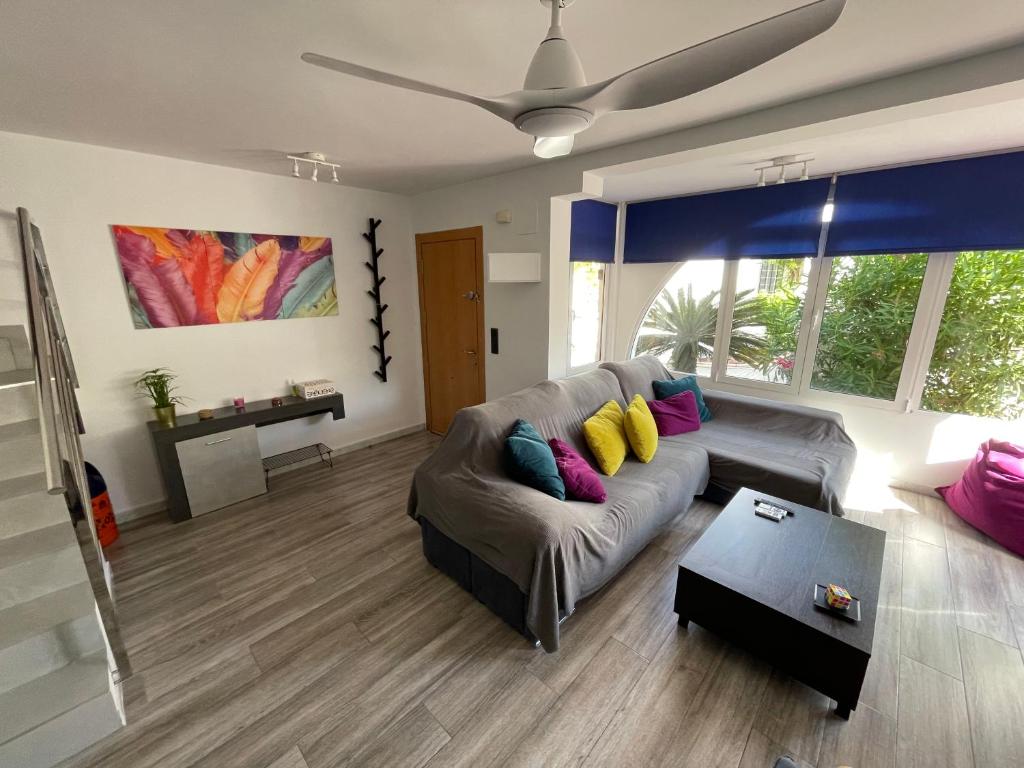 uma sala de estar com um sofá com almofadas coloridas em Costa Hispania 230 em Puerto Marino