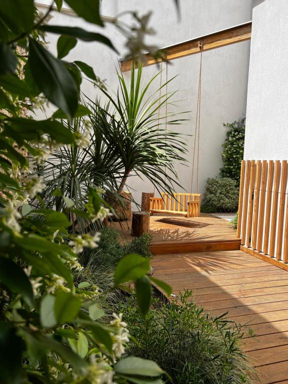 eine Holzterrasse mit einer Bank und einigen Pflanzen in der Unterkunft Lily l'Acrobate Aubagne-Cassis-Aix en Provence in Aubagne