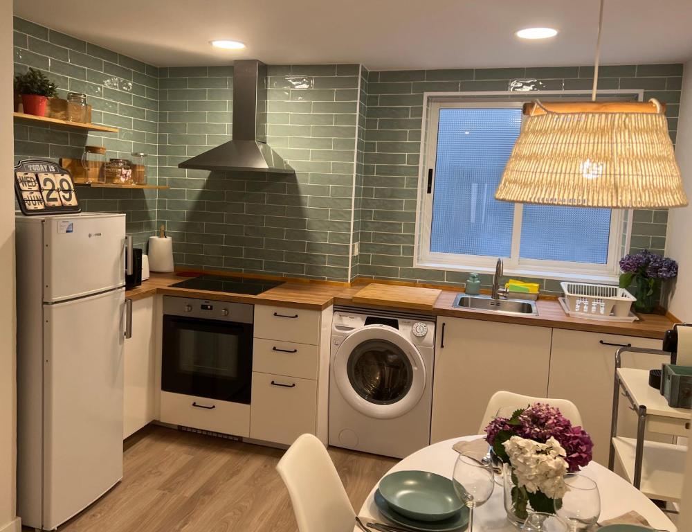 a kitchen with a washing machine and a sink at Casa Güelita in Oviedo