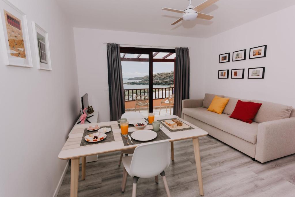 una sala de estar con una mesa y un sofá en Alma 28, en Los Cancajos