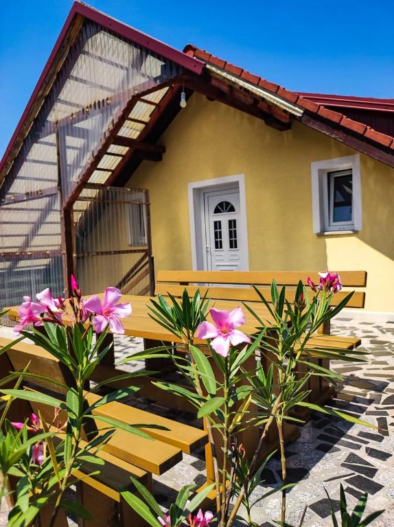 a bench in front of a house with flowers at Apartman Majetić in Seliste Dreznicko