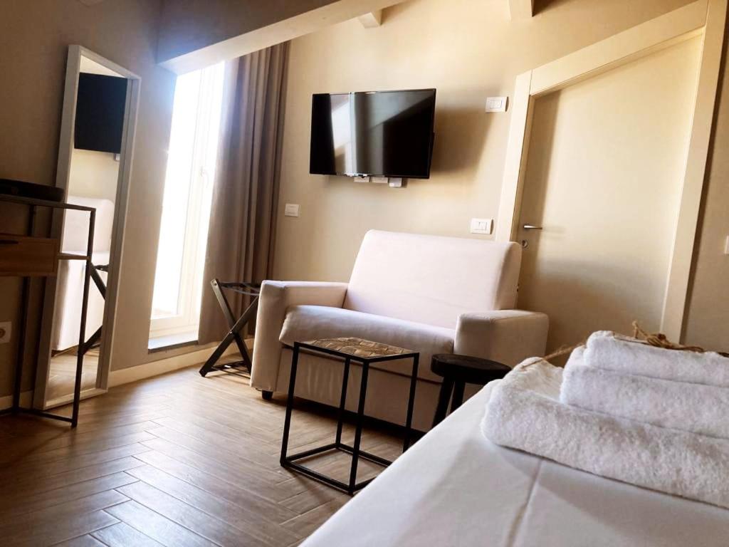 a living room with a couch and a tv on the wall at Gatto Bianco Rooms 42 in Bergamo