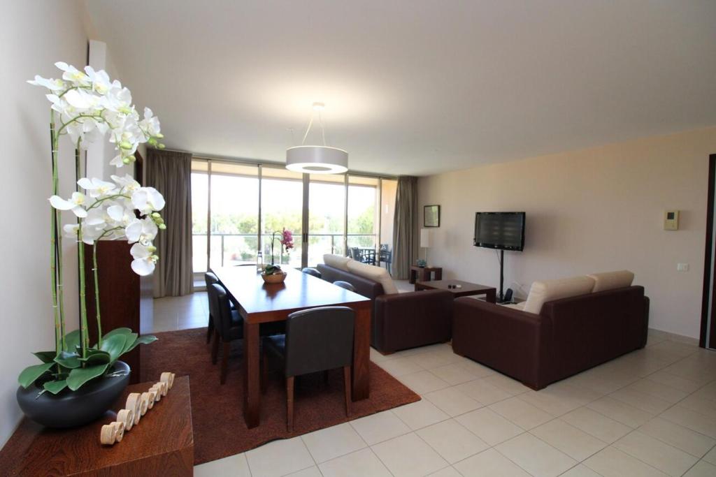 een woonkamer met een bank en een tafel bij Apartment Villa das Lagoas - By Dalma Portuguesa in Galé