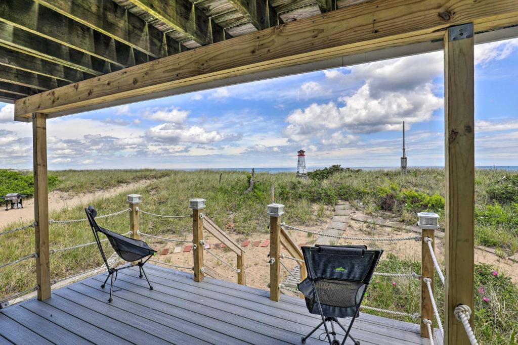 two chairs on a deck with a view of the beach at Charming Oceanfront Home on Salisbury Beach in Salisbury