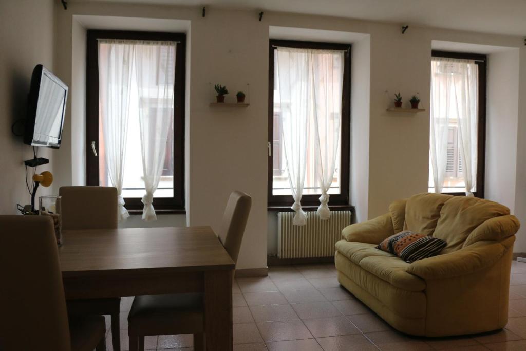 a living room with a couch and a table and windows at Le Androne di Trento in Trento