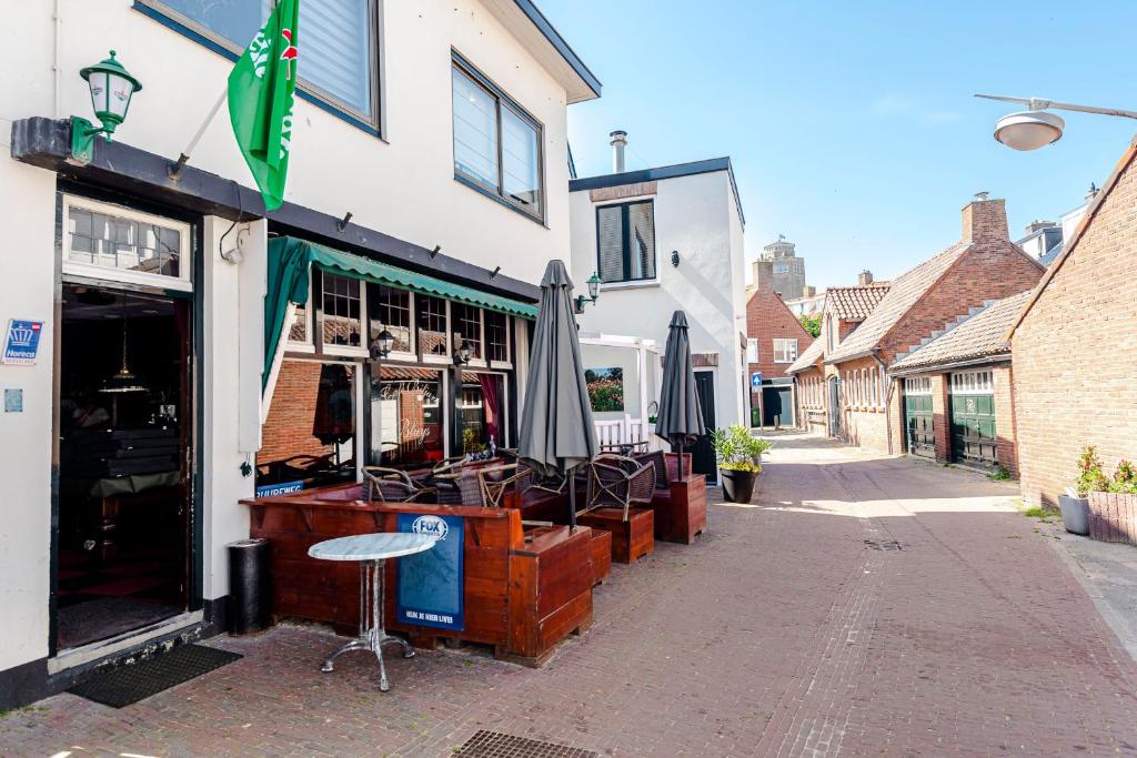 a store with umbrellas and chairs outside of a building at Bluys Apartment in Zandvoort