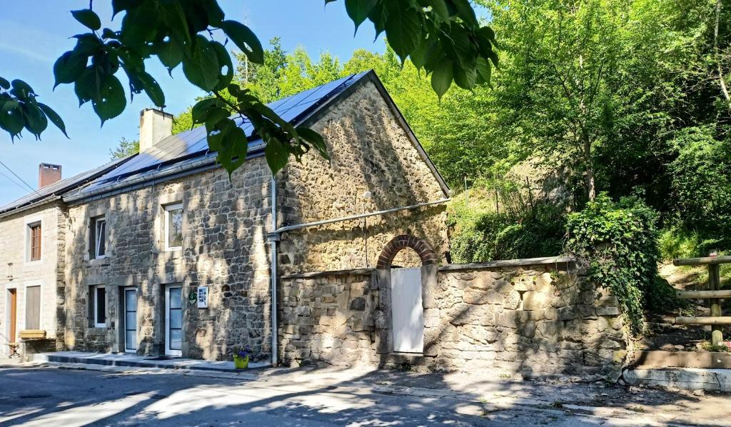 een oud stenen huis met een stenen muur bij Les Gites d'Olloy - Le Beauséjour in Olloy-sur-Viroin