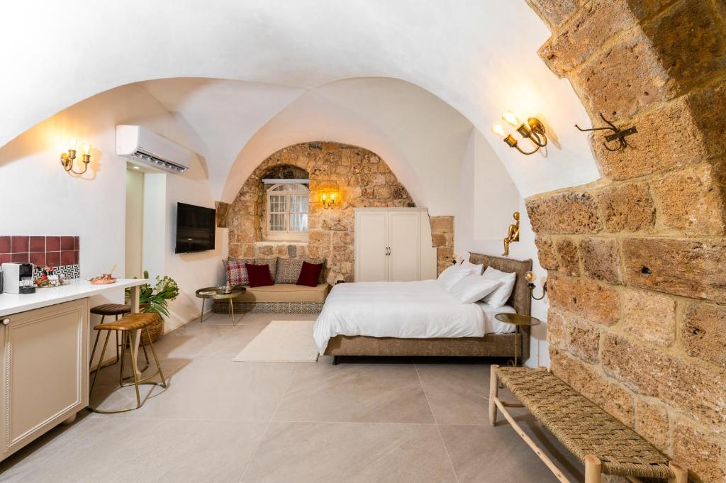 a bedroom with a bed and a stone wall at Jozefin in ‘Akko
