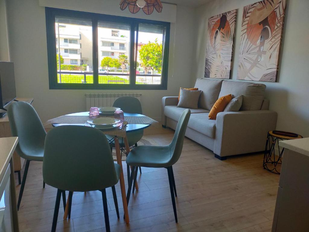 un soggiorno con divano, tavolo e sedie di Apartamento Sofía a Llanes