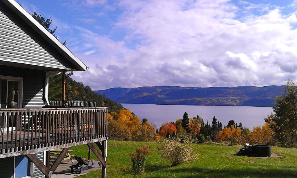 ein Haus mit einer Terrasse und Seeblick in der Unterkunft Villa de la Montagne in Sainte-Rose-du-Nord