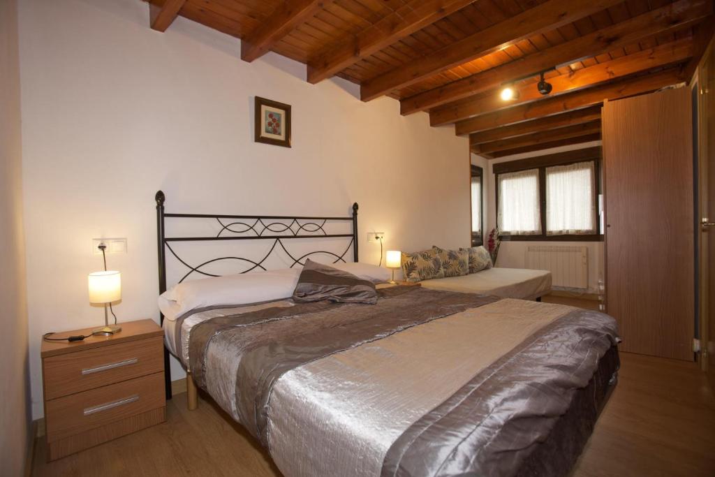 - une chambre avec un lit et une table avec une lampe dans l'établissement Casa Criseva II, à Avín