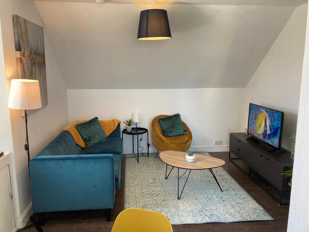 sala de estar con sofá azul y mesa en 2 Bedroom apartment, with free parking, en Largs