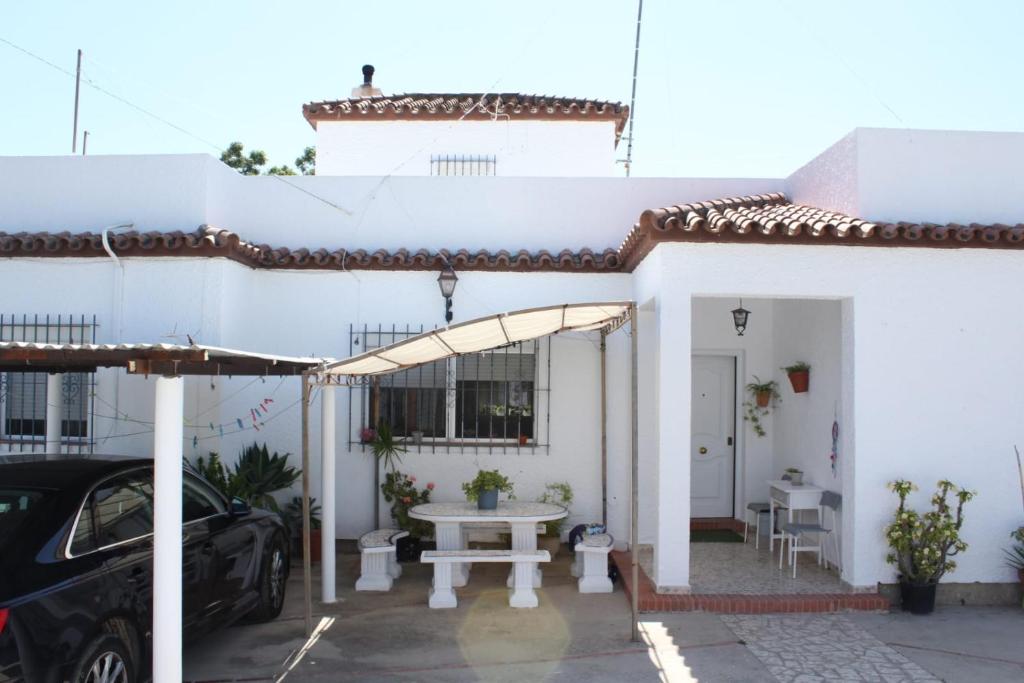 uma casa branca com uma mesa num parque de estacionamento em Casa La Maceta em Cádis