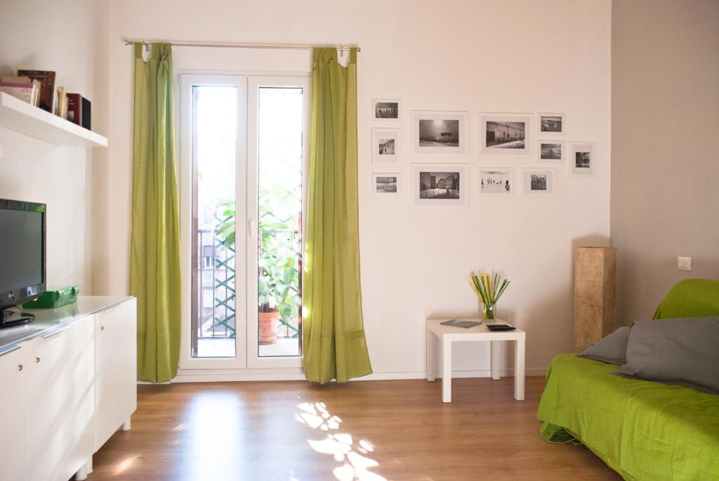 a living room with a green couch and a window at Welcome Friends in Rome