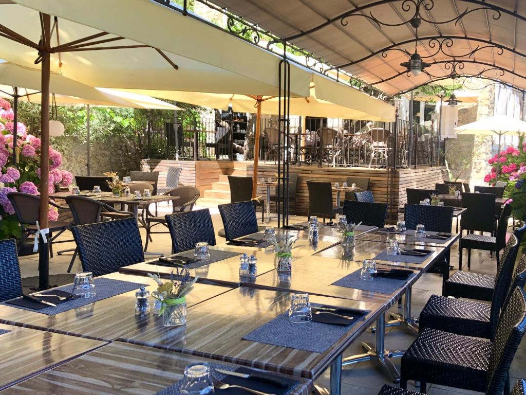 un gruppo di tavoli e sedie in un ristorante di Hotel U Campanile a Vivario