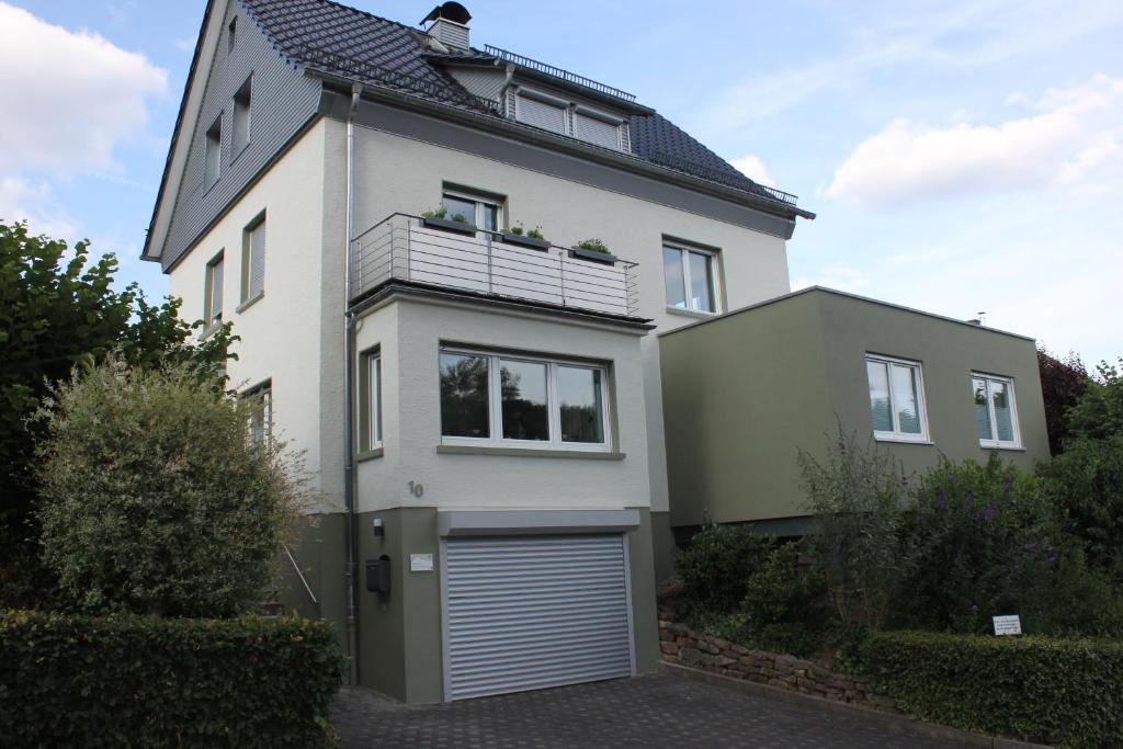 a large white house with a garage at Erholung am Vulkanradweg - 4 Sterne DTV Zertifiziert in Bad Salzschlirf