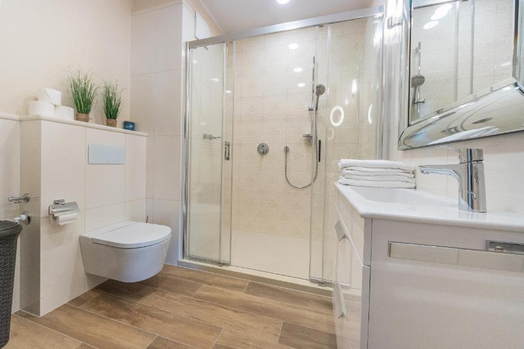 łazienka z prysznicem, toaletą i umywalką w obiekcie Pomorskie Apartamenty Bernadowska Green Deluxe w mieście Gdynia