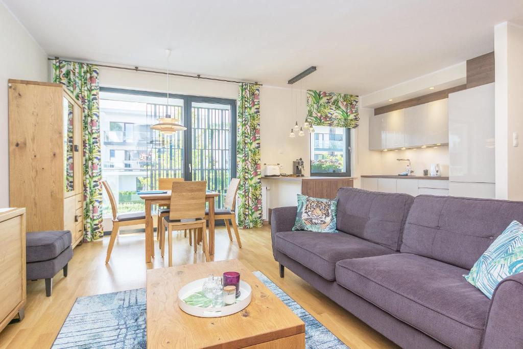salon z kanapą i stołem w obiekcie Pomorskie Apartamenty Bernadowska Green Deluxe w mieście Gdynia
