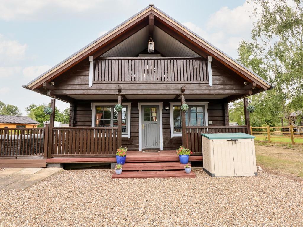 a log cabin with a porch and a deck at The Lodge in King's Lynn
