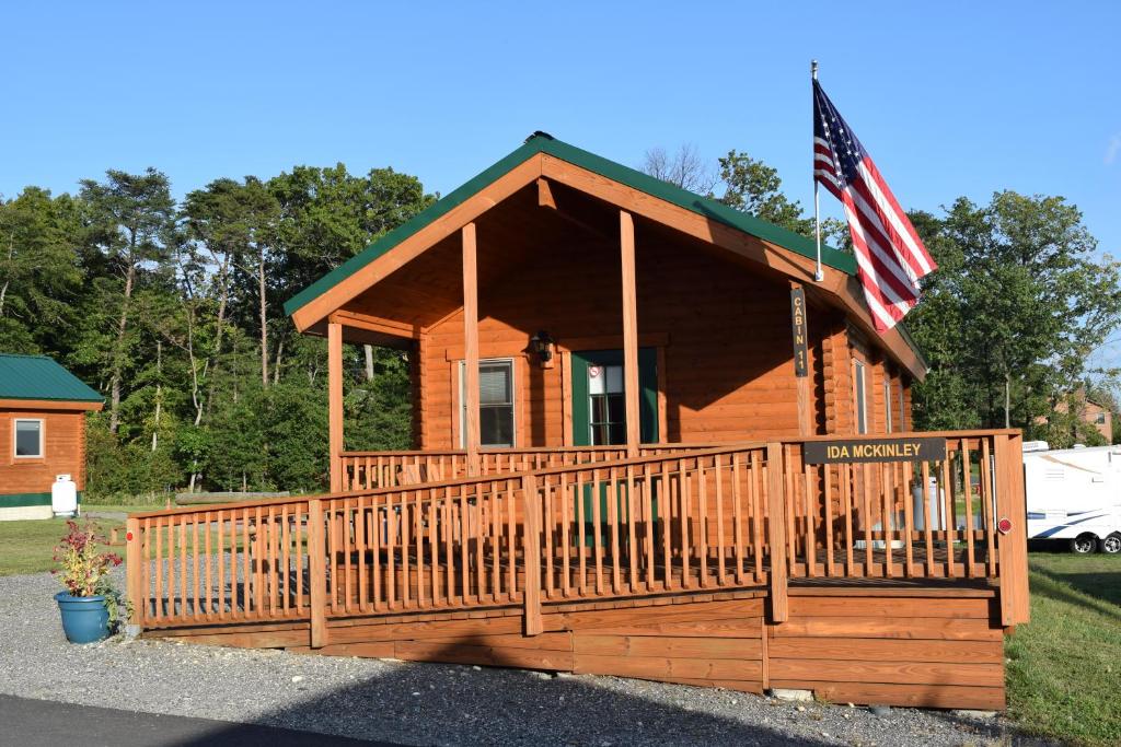 eine kleine Hütte mit amerikanischer Flagge auf der Veranda in der Unterkunft Cherry Hill Park in College Park