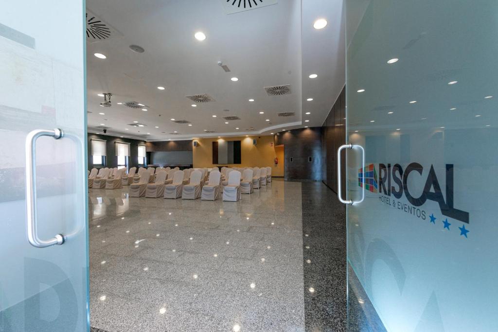 a conference room with white chairs in a building at Sercotel Riscal in Puerto Lumbreras