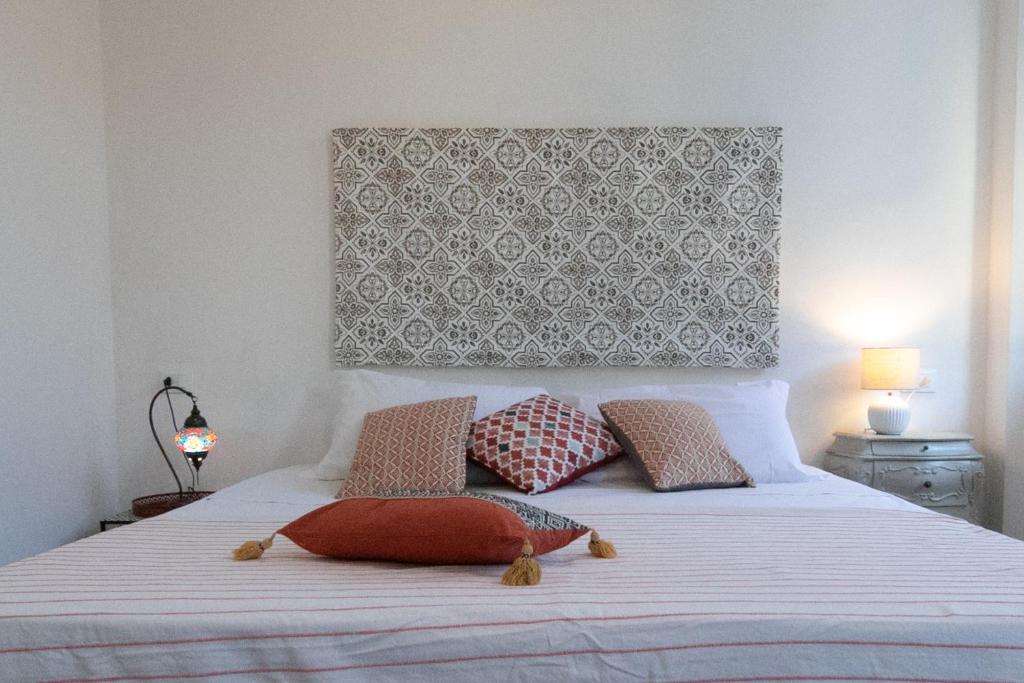 um quarto com uma cama branca e 2 almofadas em Rooms in Chiassetto em Pisa