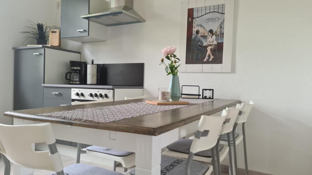 eine Küche mit einer Theke mit Stühlen und einem Tisch in der Unterkunft Das Tor zum Vogtland !! in Rodewisch