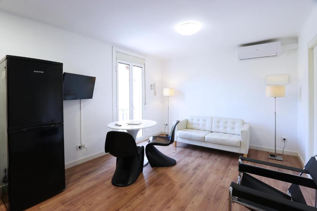 uma sala de estar com um frigorífico preto e um sofá branco em Apartments in the Center of Arenys em Arenys de Mar