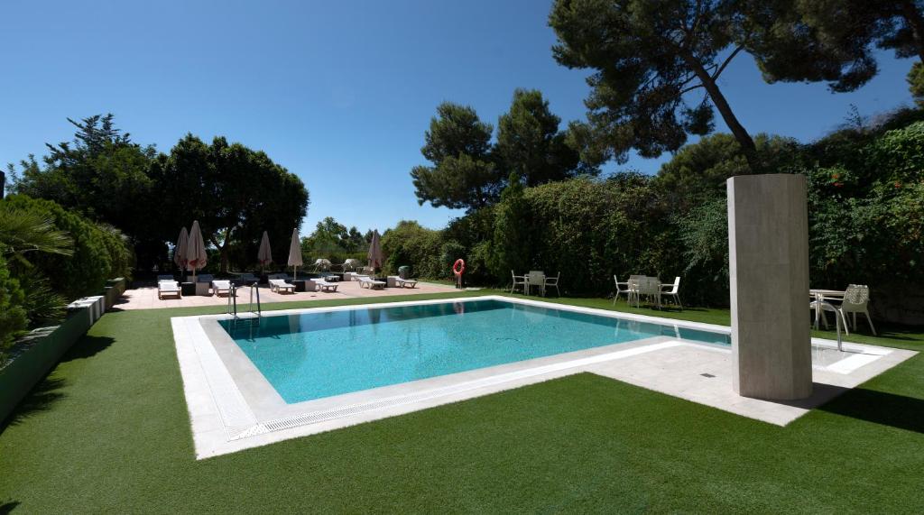 a swimming pool in a yard with green grass at Sercotel Riscal in Puerto Lumbreras