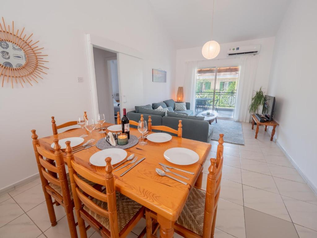 - une salle à manger et un salon avec une table en bois dans l'établissement The Salnik Beach Apartment, à Limassol