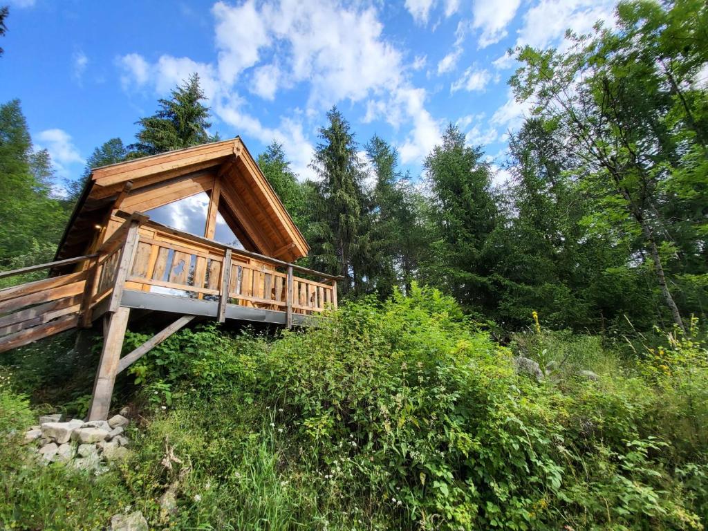 une cabane dans les arbres avec une terrasse dans les bois dans l'établissement Les cabanes du domaine de l Esperluette, au Lauzet-Ubaye