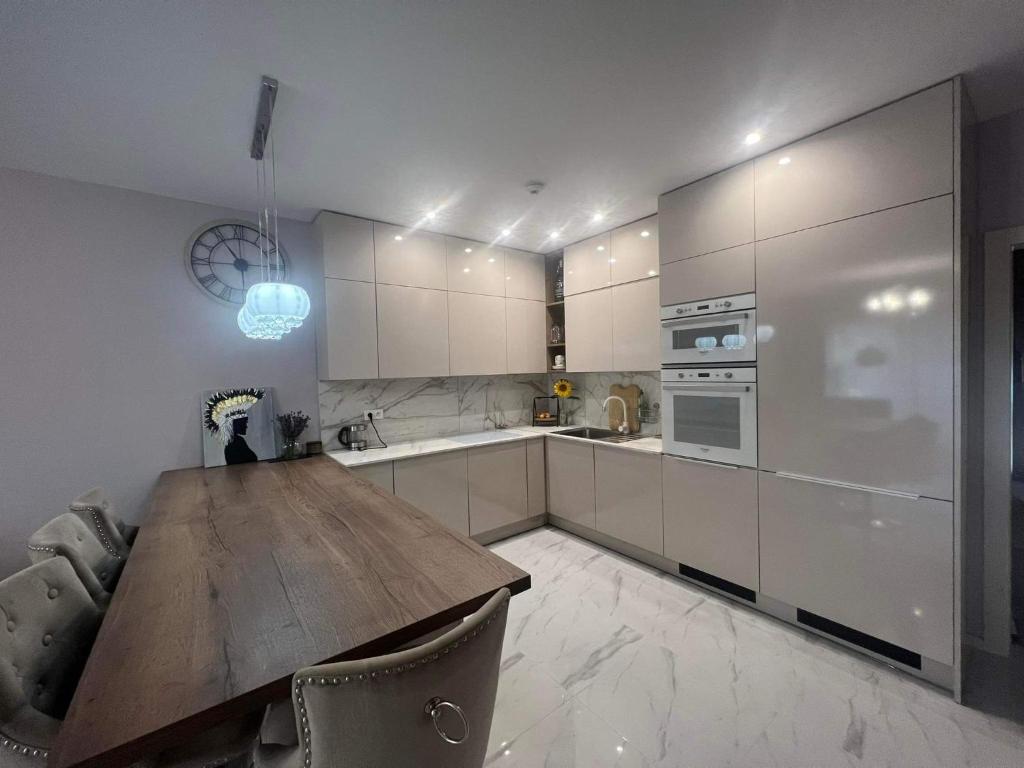 een keuken met een houten tafel en een aanrechtblad bij Beverly Hills House pri potoku by Pinkreal in Solčany