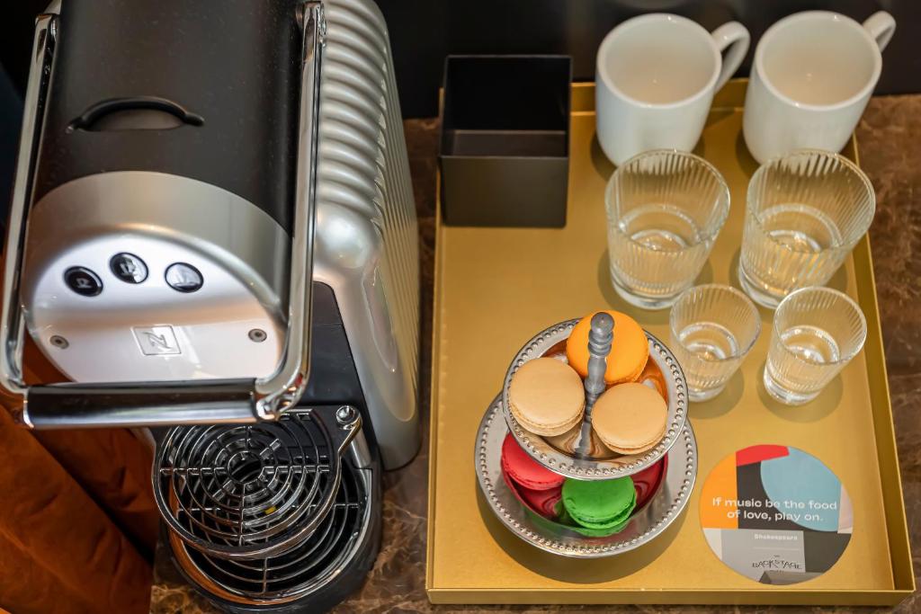 a table with a coffee maker and some glasses at Backstage Hotel - an Atlas Boutique Hotel in Tel Aviv