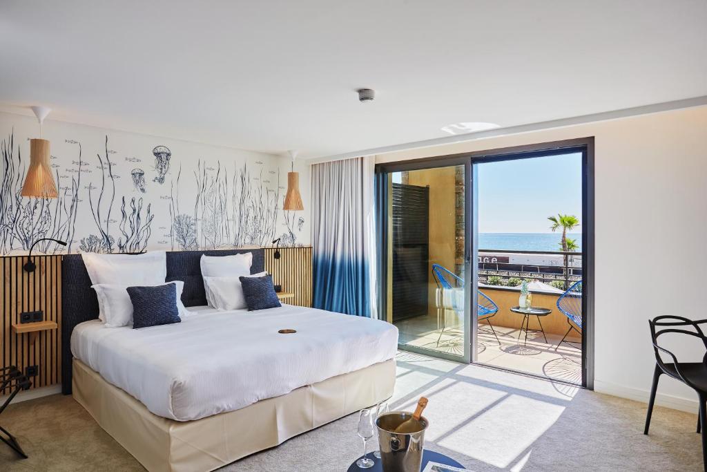 a bedroom with a bed and a view of the ocean at EDEN HÔTEL in Sainte-Maxime