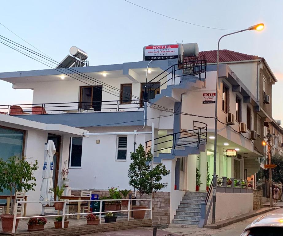 a white building with a staircase in front of it at City Center in Sarandë