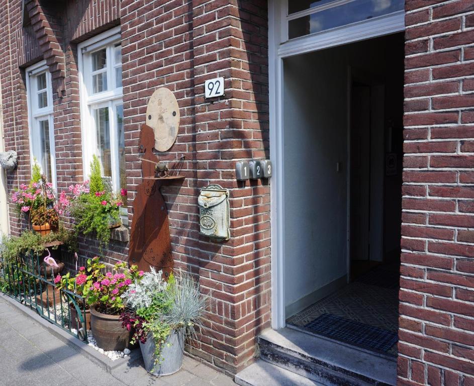 ein Backsteingebäude mit Pflanzen und einem Schild darauf in der Unterkunft De bezige bij in Kerkrade