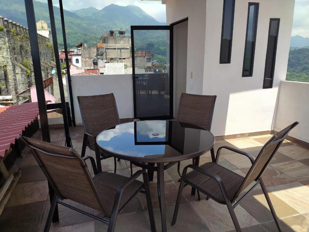 einen Tisch und Stühle auf einem Balkon mit Aussicht in der Unterkunft verde amanecer in Xilitla