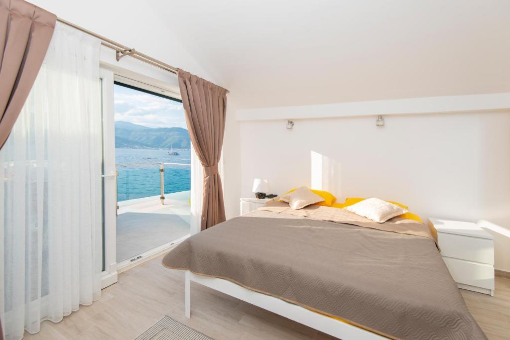 a bedroom with a bed and a large window at Casa del Mare Bjelila in Tivat