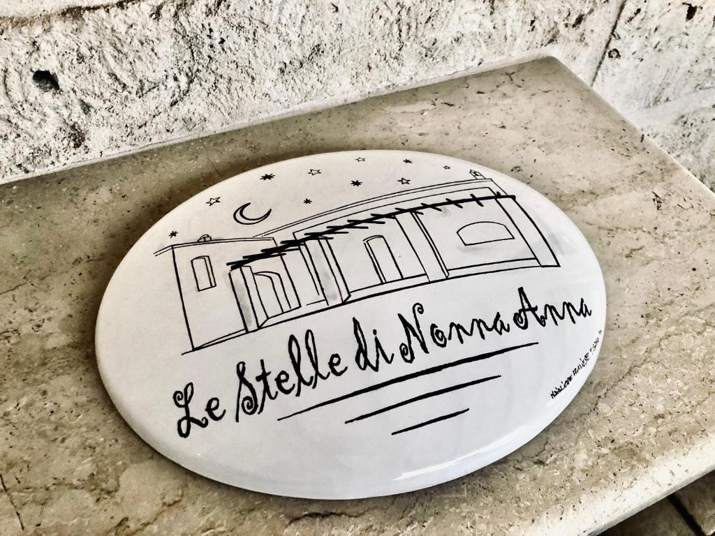 a white plate with a drawing of a building at Le Stelle di Nonna Anna in Monopoli