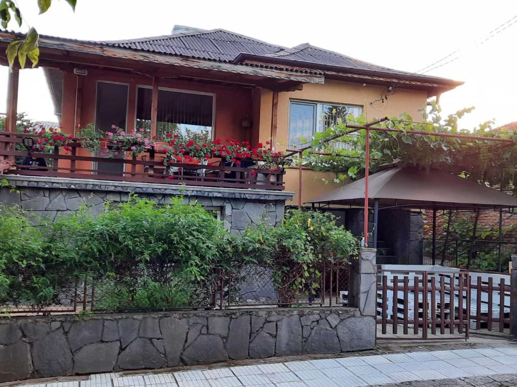 Una casa con flores en el balcón. en Апартаменти за гости ,,Тракия'', en Hisarya