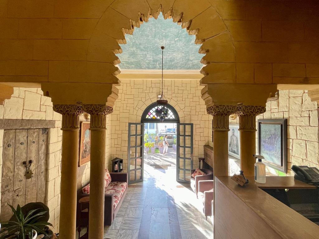 a hallway in a building with an archway at Hotel Lutece in Rabat