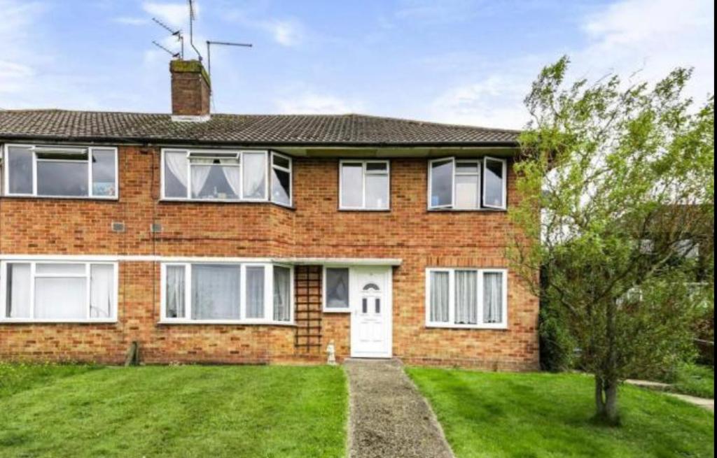 a brick house with a lawn in front of it at Two Double Bedroom Maisonette with rear garden. 